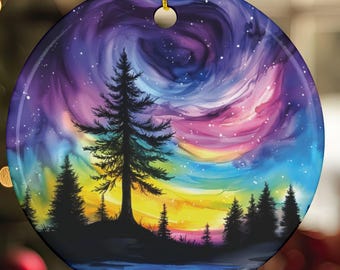 May include: Round ceramic Christmas ornament featuring a colorful landscape painting. The design includes a swirling, starry sky in shades of purple, pink, and blue, with silhouetted trees and a body of water at the bottom.