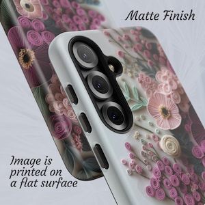 Puede incluir: Una funda de tel&eacute;fono con acabado mate, con un dise&ntilde;o floral en tonos rosa, morado y blanco. La imagen est&aacute; impresa sobre una superficie plana. La funda tiene una c&aacute;mara y botones.