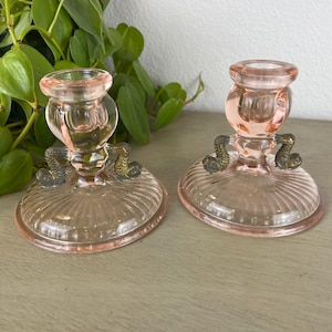 May include: A white ceramic mug with a black handle and the text "But First, Coffee" in a black, bold font. The mug is on a white surface.