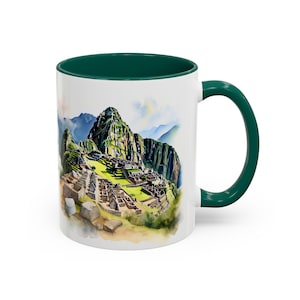 Op de afbeelding: Witte keramische mok met een groene binnenkant en handvat. De mok heeft een aquarel illustratie van Machu Picchu, met de oude Inca-citadel in de bergen. Het ontwerp bevat groene, bruine en blauwe tinten.