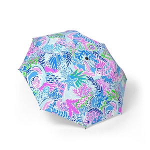 May include: An open umbrella with a bright, patterned design. The pattern includes blue, pink, and green floral and aquatic elements. The umbrella is set against a white background, highlighting its vivid colours and intricate details.