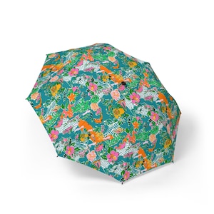 May include: A patterned umbrella with a teal background and a colourful floral design. The pattern includes pink, orange, yellow, and green flowers and foliage. White dotted and striped accents are also visible.