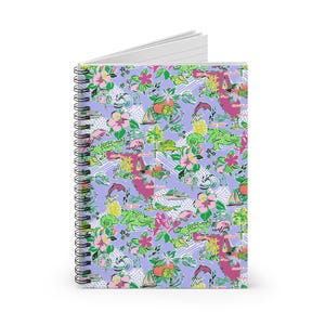Könnte beinhalten: Spiralgebundenes Notizbuch mit einem lebendigen, farbenfrohen Muster. Das Design zeigt ein sich wiederholendes Motiv aus Blumen, Alligatoren, Segelbooten und anderen tropischen Elementen auf einem lavendelfarbenen Hintergrund. Das Notizbuch hat eine silberne Spiralbindung.