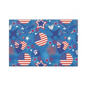 Peut inclure: Objet décoratif rectangulaire avec un motif patriotique. Le motif présente des drapeaux américains, des aigles, des étoiles, des feux d'artifice et la Statue de la Liberté sur fond bleu. Un objet décoratif pour la maison.