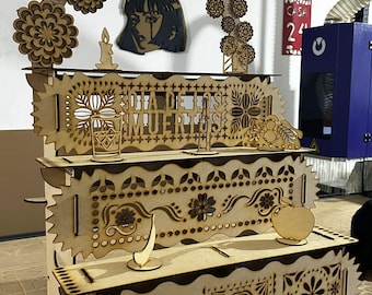 May include: A multi-tiered, laser-cut wooden display shelf with intricate Day of the Dead-themed designs. The shelf features decorative cutouts of flowers, skulls, and the text "DIA DE LOS MUERTOS". Additional wooden cutouts include a candle, a woman's face, and an apple.