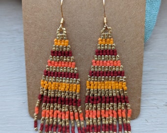 dangling golden and burgundy seed earrings