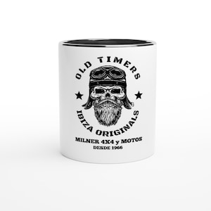 Puede incluir: Taza de cerámica blanca con borde negro. La taza presenta una ilustración en blanco y negro de una calavera con casco y gafas. El texto "Old Timers Ibiza Originals" está escrito en un círculo alrededor de la calavera. Debajo de la calavera, el texto "Milner 4x4 y Motos Desde 1966" está escrito.