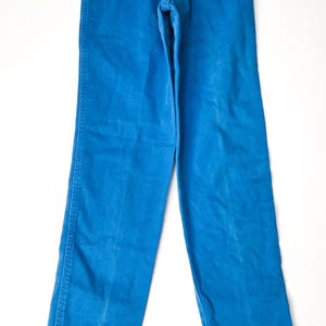 May include: Bright blue denim pants. The pants have a classic five-pocket design with a button and zipper closure. The pants are made of a sturdy denim material and have a straight leg cut. The pants are a vibrant shade of blue.