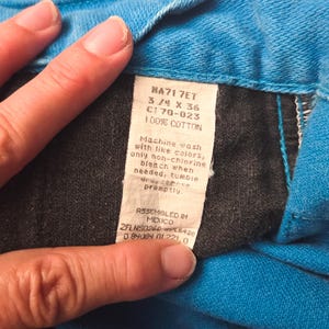 May include: Close-up of a tag from a pair of blue jeans. The tag reads "NA71 7ET 3/4 X 36 C170-023 100% COTTON". The tag also includes washing instructions and states "ASSEMBLED IN MEXICO".