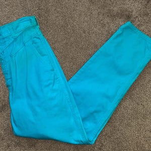 May include: A pair of turquoise blue trousers. The trousers have a straight leg and a high waist.
