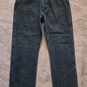 以下が含まれることがあります： ダークグレーのデニムジーンズ。クラシックな5ポケットデザイン。ボタンとジッパー開閉、ベルトループ、ストレートレッグフィット。ステッチはコントラストカラーです。
