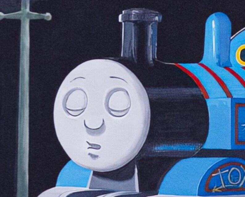 May include: A blue steam locomotive toy with a white face featuring closed eyes and a small mouth. The engine has a black smokestack, red stripes on its side, and a light blue cab. A tall, thin, pale green utility pole stands to the left.