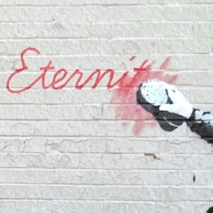 Puede incluir: Una pared de ladrillo blanco con texto en cursiva pintado con aerosol rojo que dice Eternity. A la derecha del texto, un elemento gr&aacute;fico en blanco y negro muestra una mano con guante que oculta parcialmente el final de la palabra con pintura roja.