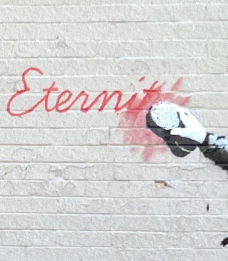 Puede incluir: Una pared de ladrillo blanco con texto en cursiva pintado con aerosol rojo que dice Eternity. A la derecha del texto, un elemento gr&aacute;fico en blanco y negro muestra una mano con guante que oculta parcialmente el final de la palabra con pintura roja.