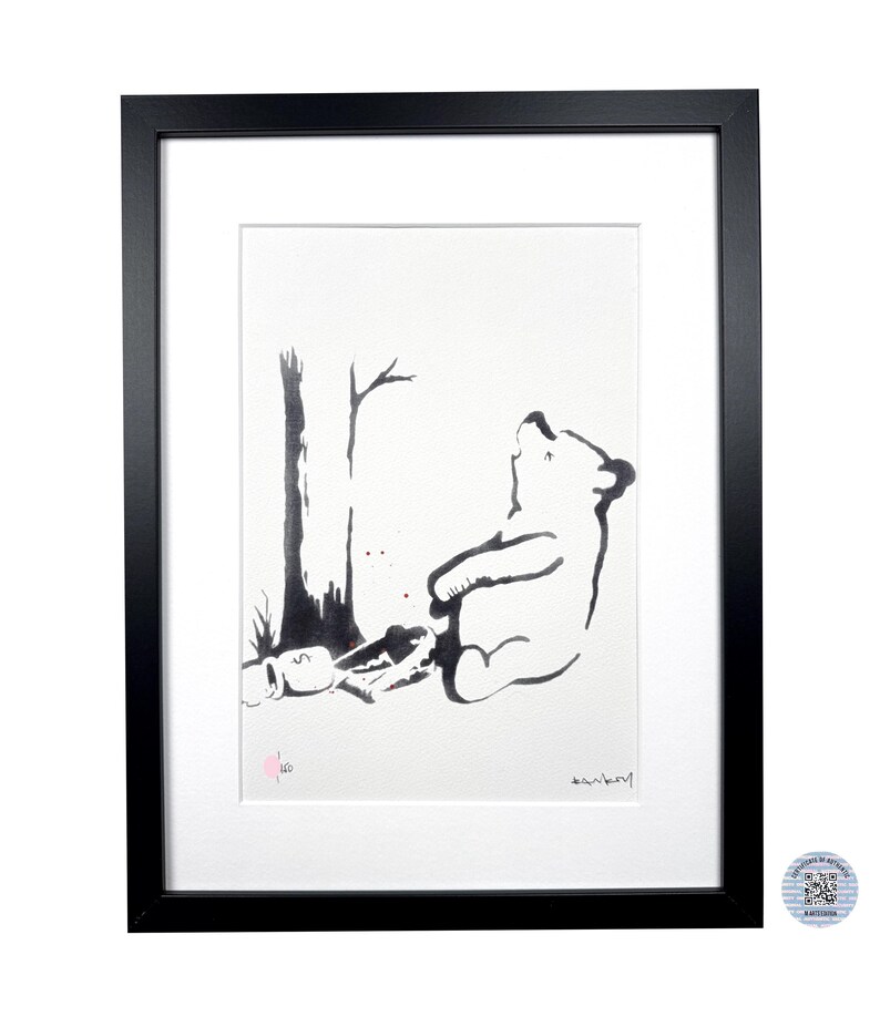 May include: A framed black and white print featuring a stylized bear sitting next to a tree. The artwork includes a small pink circular stamp with the number 160 and a signature in the bottom right corner, all encased in a black frame.