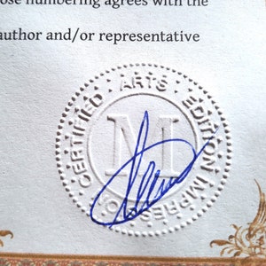 May include: A white, round, embossed seal with the text "CERTIFIED ARTS EDITION" and the letter "M" in the center. The seal has a blue signature inside.