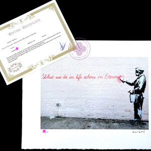 Puede incluir: Una impresi&oacute;n art&iacute;stica de Banksy titulada What we do in life echoes in Eternity que muestra a una persona pintando en una pared de ladrillo, acompa&ntilde;ada de un certificado con borde dorado, n&uacute;mero de edici&oacute;n 1/150 y un sello de galer&iacute;a.