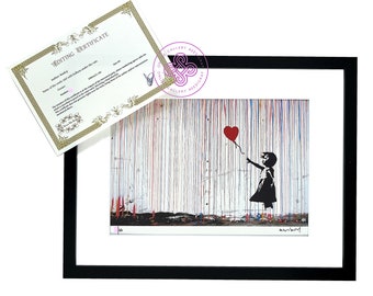 May include: A framed print featuring a black silhouette of a person reaching for a red heart-shaped balloon against a background of vertical blue, red, and yellow paint drips, accompanied by a rectangular white certificate of authenticity.