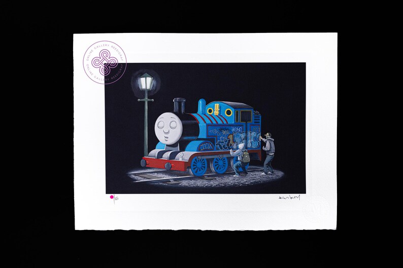 May include: A rectangular art print on white paper featuring a blue steam engine train with a white face, red bumper, and blue wheels. Two figures are spray painting graffiti on the side of the train under a street lamp against a black background.