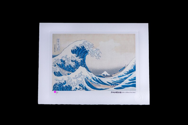 K&ouml;nnte beinhalten: Ein gerahmter Druck von Hokusais "Die gro&szlig;e Welle vor Kanagawa". Das Kunstwerk zeigt eine gro&szlig;e Meereswelle mit einem Berg im Hintergrund. Die Welle ist tiefblau mit wei&szlig;em Schaum. Der Druck befindet sich auf wei&szlig;em Hintergrund.