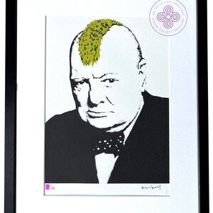 May include: A framed print featuring a high-contrast black and white portrait of Winston Churchill with a bright olive green mohawk hairstyle. The artwork includes a small pink square, a signature, and a circular logo in the top right corner.