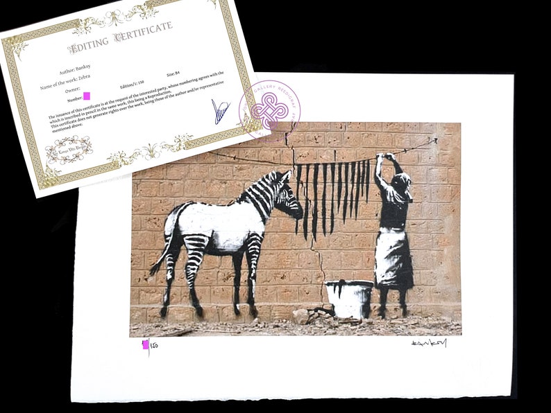 May include: A Banksy art print titled Zebra featuring a black and white zebra standing next to a figure hanging black stripes on a clothesline against a brick wall, accompanied by an Editing Certificate with the text Author: Banksy, Name of the work: Zebra.
