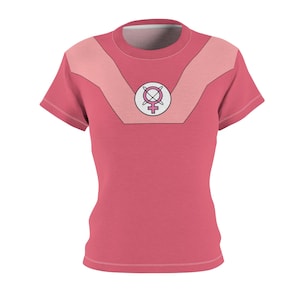 Puede incluir: Una camiseta rosa con un círculo blanco y un símbolo femenino rosa con una X rosa encima.