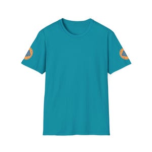 May include: A turquoise blue t-shirt with a small orange and blue graphic on each sleeve.