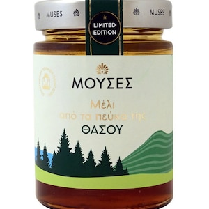 Puede incluir: Un tarro de vidrio de miel con una etiqueta blanca que dice "ΜΟΥΣΕΣ" en letras doradas. La etiqueta también dice "Μέλι από τα πεύκα της ΘΑΣΟΥ" en letras doradas. El tarro tiene una tapa plateada con una pegatina verde y dorada que dice "EDICIÓN LIMITADA".