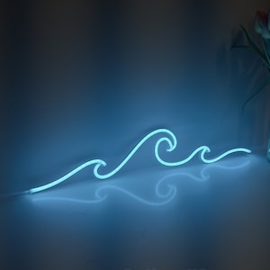 May include: A blue neon light sign shaped like three ocean waves. The sign is lit and casting a blue glow on the surface it is sitting on. The sign is reflected in the surface below it.