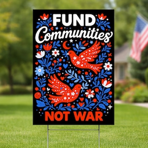 May include: A black yard sign with the words "FUND Communities NOT WAR" in white. The sign features red birds and blue floral designs. The sign is displayed on a green lawn with a house and American flag in the background.