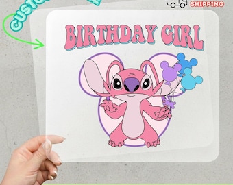 May include: A DTF transfer featuring a pink cartoon character holding balloons. The words "BIRTHDAY GIRL" are in pink bubble letters. The transfer is labeled "CUSTOMIZABLE" and "READY TO APPLY".