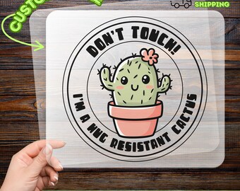 May include: A DTF transfer featuring a cartoon cactus in a pink pot with the text "DON'T TOUCH! I'M A HUG RESISTANT CACTUS." The transfer is customizable and ready to apply.