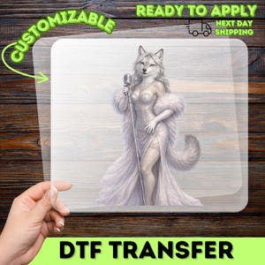 May include: A DTF transfer sheet featuring a white wolf character standing and holding a vintage microphone. The character wears a sparkling white strapless gown with a high slit and a matching fur stole. The design includes a fluffy tail.