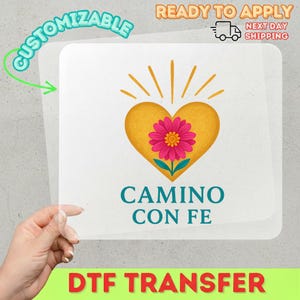 May include: A DTF transfer featuring a yellow heart with a pink flower and the text "CAMINO CON FE" in teal. The word "CUSTOMIZABLE" is in a green bubble, and "READY TO APPLY" is at the top.