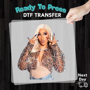 A person with blonde hair and makeup is making a peace sign with their fingers, wearing a sparkly jacket.
