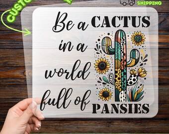 May include: A DTF transfer with the text "Be a CACTUS in a world full of PANSIES." The design features a colorful cactus with sunflowers. The transfer is customizable and ready to apply.