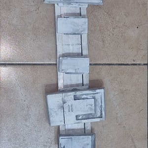 Könnte beinhalten: Ein weißer Gürtel mit mehreren rechteckigen Fächern und einem zylindrischen Behälter. Der Gürtel ist aus einem strukturierten Material gefertigt und hat einen schwarzen Riemen.