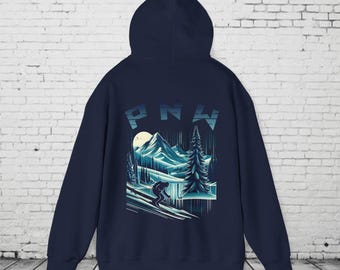 Può includere: Una felpa con cappuccio blu navy con una stampa grafica di uno sciatore in un paesaggio montano. La grafica include anche il testo "PNW" in un font stilizzato.