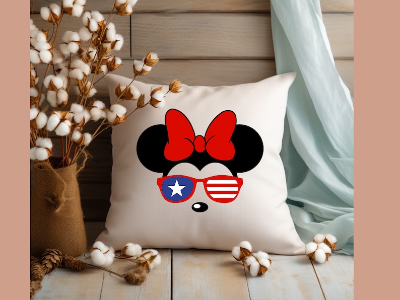 May include: White pillow with a red, white, and blue cartoon mouse wearing sunglasses. The mouse has a red bow on its head.