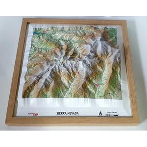 Puede incluir: Un mapa topográfico 3D enmarcado de Sierra Nevada, con relieve detallado y curvas de nivel. El mapa está en un marco de madera clara, con el texto "SIERRA NEVADA" impreso en la parte inferior.