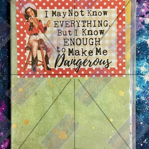 May include: A rectangular card in a clear plastic sleeve featuring a vintage-style illustration of a person in western attire sitting on a stool. The text reads: I May Not Know EVERYTHING, But I Know ENOUGH to Make Me Dangerous, set on a red polka dot border.