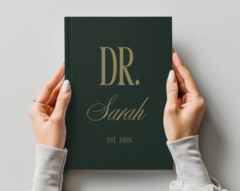 Puede incluir: Un libro de tapa dura de color verde oscuro con texto en color dorado en la portada. El texto dice DR. en una fuente serif negrita, seguido del nombre Sarah en letra cursiva, y el texto EST. 2026 en una fuente serif más pequeña y clara.