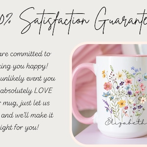 May include: White ceramic mug with a pink handle and interior, adorned with a floral bouquet design in various colors. The mug has the name "Elizabeth" written on it. The image also includes text that reads "100% Satisfaction Guarantee."