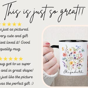 May include: White ceramic mug with a black rim and handle, adorned with a floral design in various colors. The mug has the name "Elizabeth" written on it. The text "This is just so great!!" is at the top.