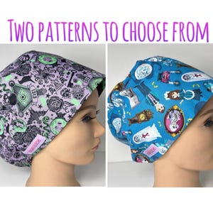 May include: Two scrub caps with the text TWO PATTERNS TO CHOOSE FROM. The left cap is light purple with black and green occult-themed graphics. The right cap is blue with a colorful pattern of cartoon characters, clocks, and framed portraits.