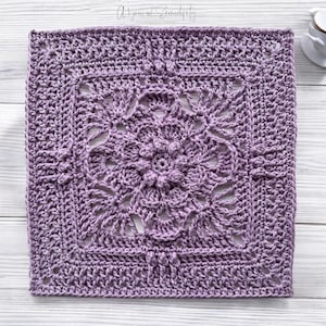 以下が含まれることがあります： 薄い紫色のレース模様の正方形のクロシェのグラニースクエアです。