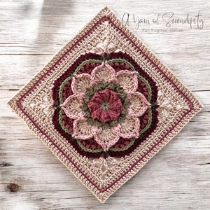 Op de afbeelding: Een gehaakt vierkant met een bloemmotief in roze, groene en bruine tinten. Het vierkant is omgeven door een rand van beige en bordeauxrood haakwerk. De tekst "A Yarn of Serendipity" en "Pam Knighton-Haener" staat in de rechterbovenhoek.