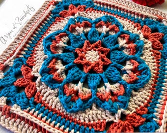 Könnte beinhalten: Ein quadratisches, handgefertigtes Häkelstück mit einem zentralen Blumendesign in Türkis, Koralle und Creme. Das komplizierte Muster umfasst eine sternförmige Mitte und einen detaillierten Rand. Der Text "a Yarn of Serendipity" ist oben links sichtbar.