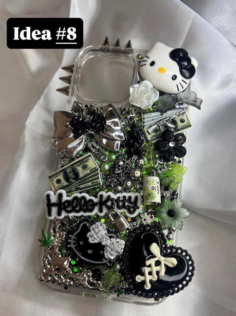 May include: Clear phone case decorated with a Hello Kitty figure, money, a bow, and other embellishments. The case has a studded border and the text "Idea #8" in the upper left corner. The words "Hello Kitty" are also visible.